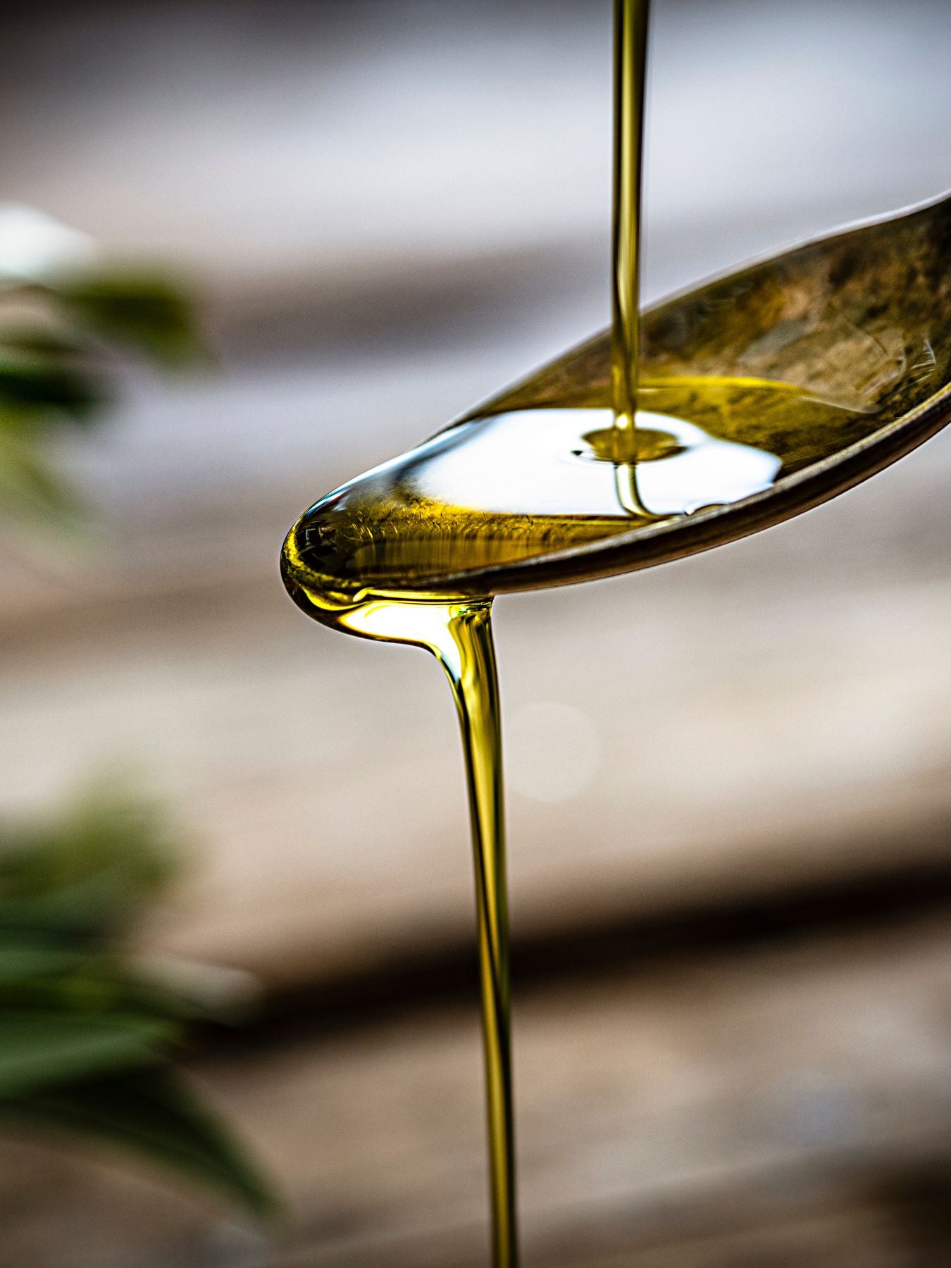 An image of natural organic oil dripping from a spoon.