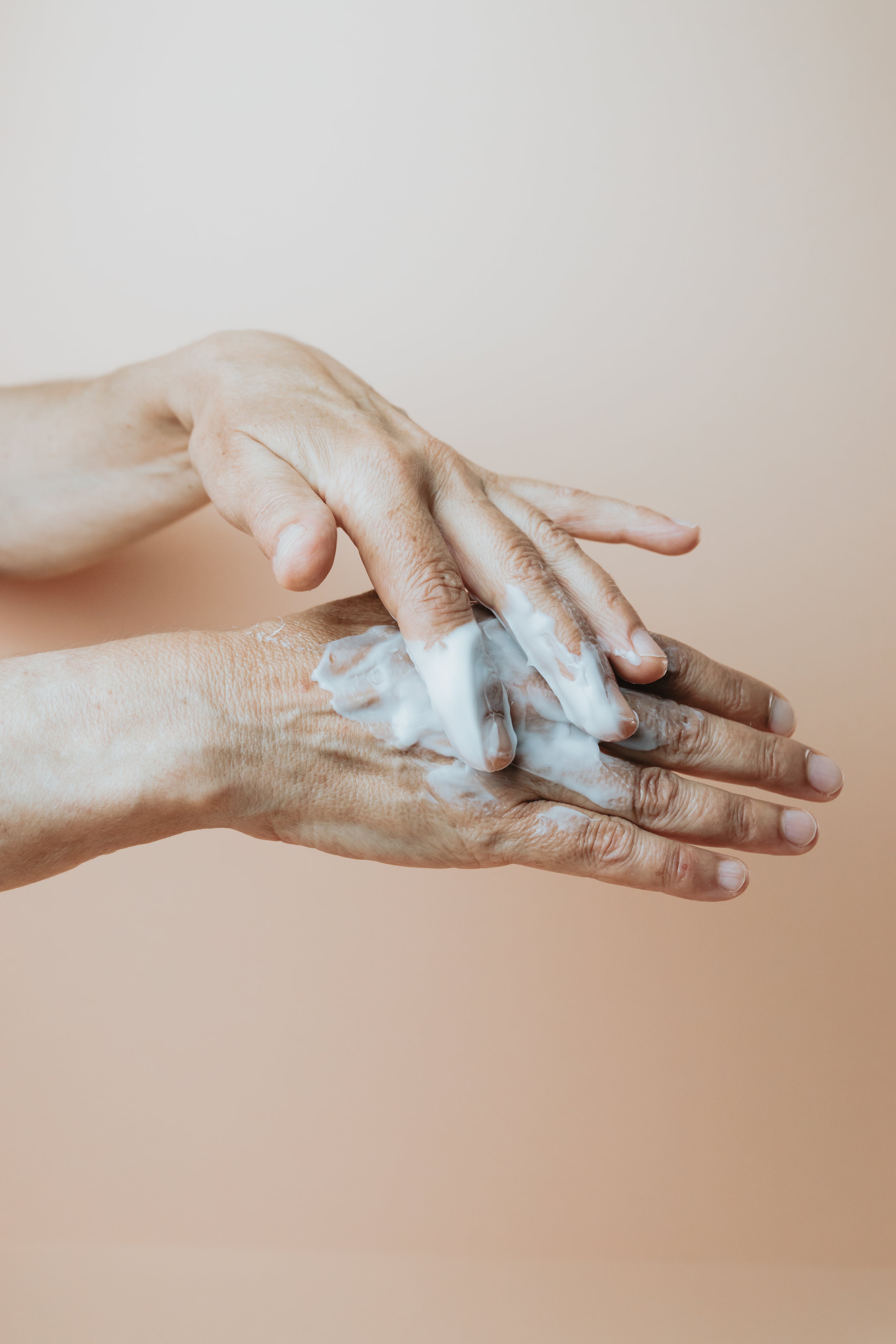 Two hands using Lamington Therapies natural organic moisturiser.